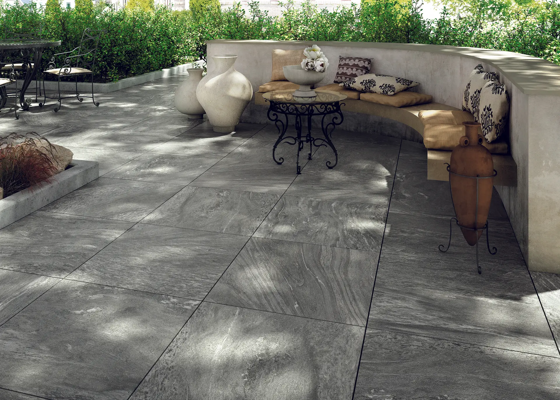 Outdoor patio with curved concrete bench, porcelain tile flooring and garden setting