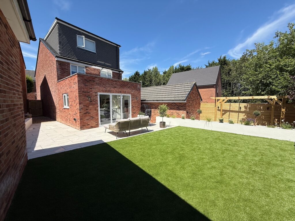 Completed garden transformation with porcelain patio, artificial lawn and contemporary planting by Gaia Crafted Landscapes