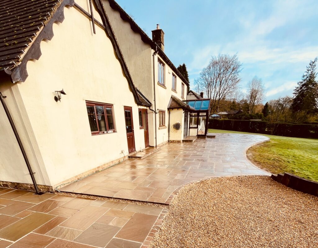 After garden transformation with large-format patio paving, decorative gravel and curved edging installed by Gaia Crafted Landscapes