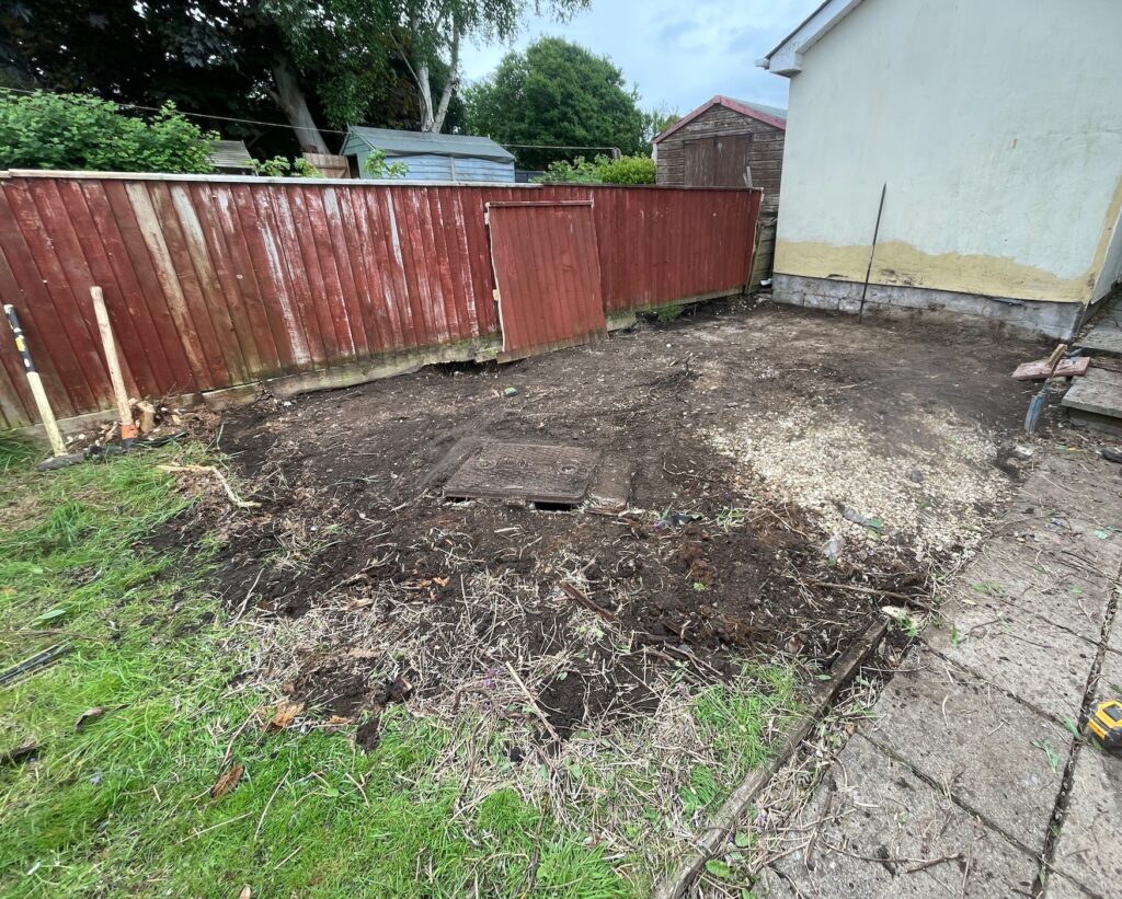 Before garden transformation showing excavated ground and old fencing in a residential garden