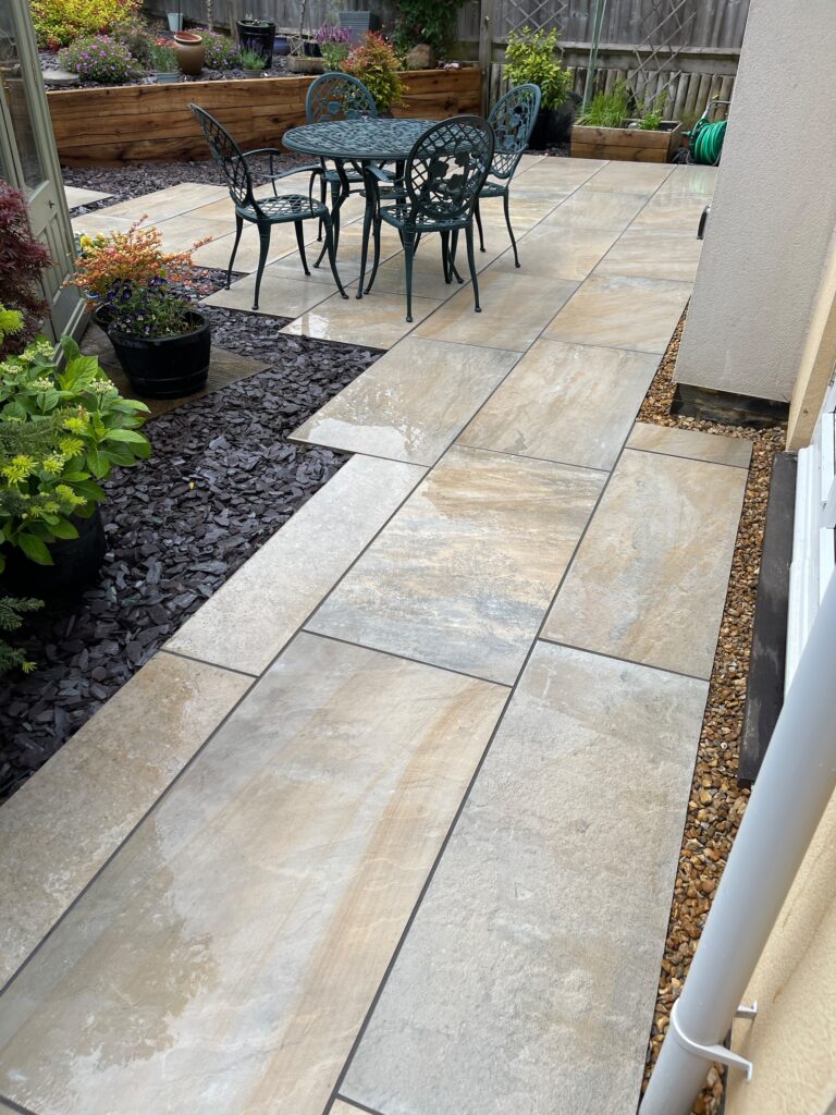 After image of porcelain paved side garden with seating area and planters